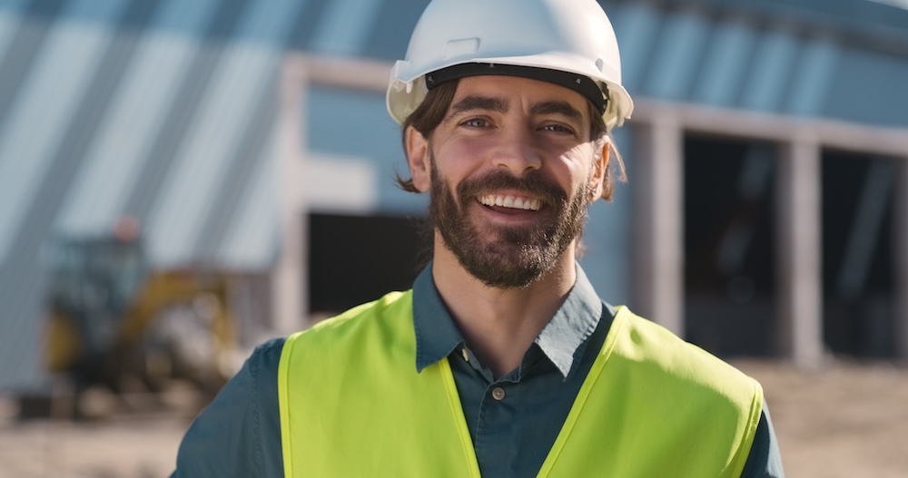 Construction, portrait and man at site for building maintenance, civil engineering and project management. Face, happy contractor and technician for industrial architecture, property and development